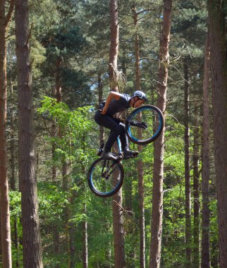 Haynes, Bedfordshire, İngiltere - 14 Mayıs 2017: Freestyle Stunt bisikletçi orta hava çok yüksek ağaçlar arka planda ile. 