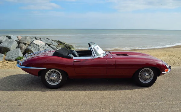 Felixstowe, Suffolk, İngiltere - 07 Mayıs 2017: Deniz kıyısındaki klasik kırmızı Jaguar E tipi Cabrio otomobil park.