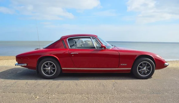 Felixstowe, Suffolk, İngiltere - 07 Mayıs 2017: Klasik Kırmızı Lotus Elan + 2 deniz kıyısındaki otomobil park.