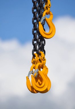 Heavy Duty Chain and Yellow Hooks against Cloud and Sky clipart