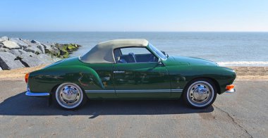 FELIXSTOWE, SUFFOLK, ENGLAND -  MAY 06, 2018: Classic Green Volkswagen Karmann Convertible parked on seafront promenade. clipart