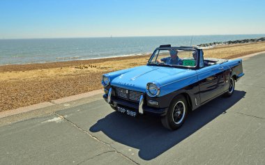 Felixstowe, Suffolk, İngiltere - Mayıs 06, 2018: Klasik Mavi Triumph Herald Üstü açılabilen Arabası Seafront Gezinti Alanı boyunca sürülüyor.