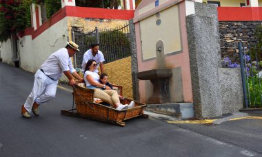 Funchal, Madeira, Portekiz - 26 Haziran 2019: Funchal Madeira Woman ve Little Girl sepetten aşağı iniyorlar.