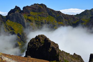  Pico do Areeiro Madeira tepeleri üzerinde mavi gökyüzü olan bulutların arasında.