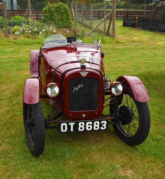 UPPER DEAN, BEDFORDSHIRE, ENGLAND - SEPTEMBER 07, 2019: Vintage Dark Red  1928 Austin Seven  parked on grass.
