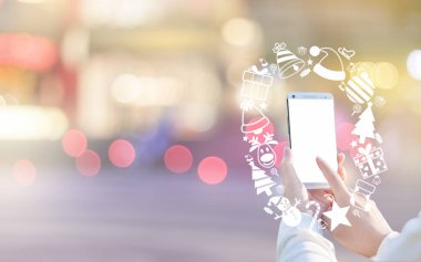 Kadın eli smartphone ve Noel simge kullanma.