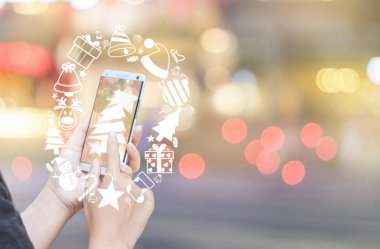Kadın eli smartphone ve Noel simge kullanma.