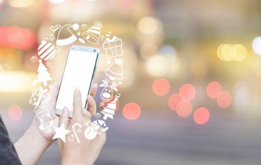 Kadın eli smartphone ve Noel simge kullanma.