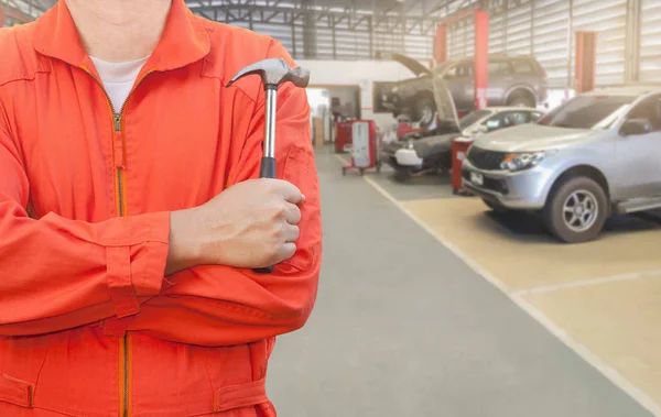 Meccanico che tiene un martello in garage — Foto Stock