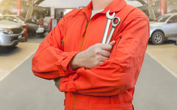 Mechaniker hält Schraubenschlüssel in Autowerkstatt — Stockfoto