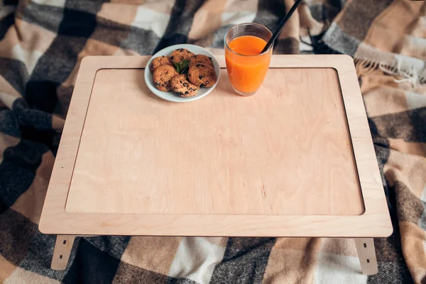 Holztisch-Attrappe mit Orangensaft und Keksen; — Stockfoto