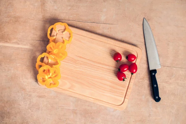 Holztisch-Attrappe mit Messer, Tomaten und Pfeffer; — Stockfoto