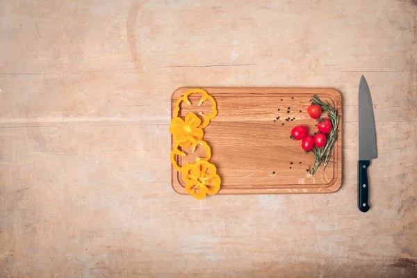 Holztisch-Attrappe mit Messer, Tomaten, Paprika und Rosmarin — Stockfoto