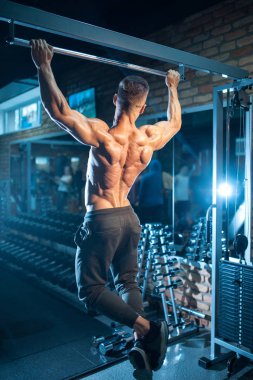 kusursuz bir beden ile genç vücut geliştirmeci havuz bar ile yukarı çekin;