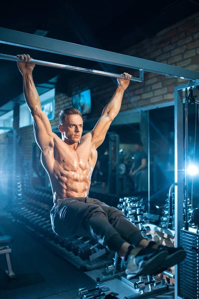 Unga bodybuilder med perfekt kropp dra upp med gym bar; — Stockfoto
