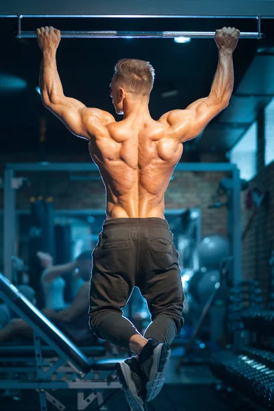 Jovem fisiculturista com corpo perfeito puxar para cima com bar ginásio ; — Fotografia de Stock