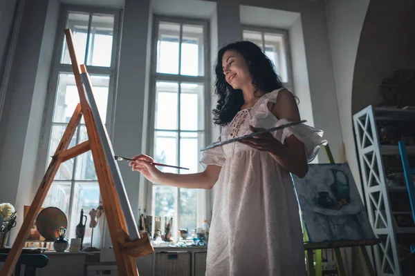 Mulher artista pintar com escovas e tintura de óleo — Fotografia de Stock