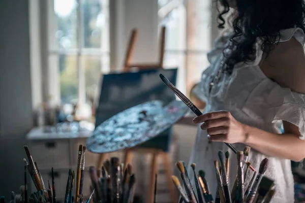 Mulher artista pintar com escovas e tintura de óleo — Fotografia de Stock