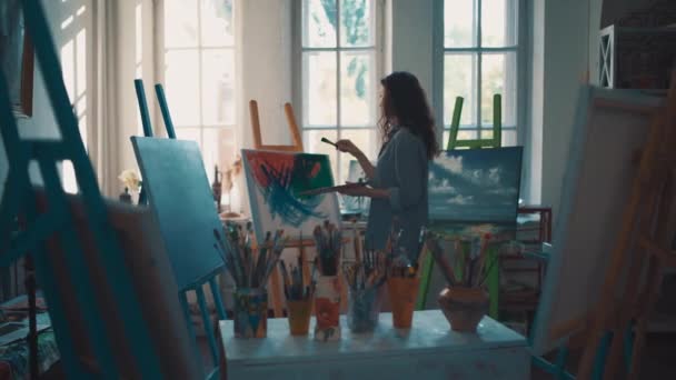 Женщина-художник рисует кисточками и масляным красителем — стоковое видео