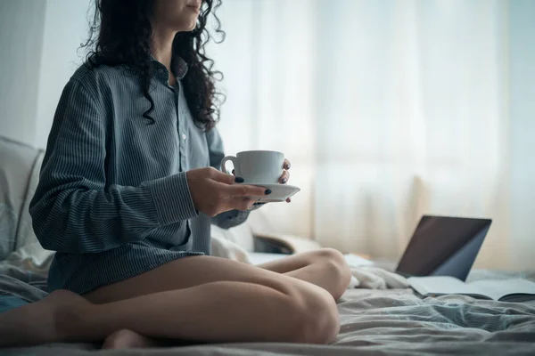 Bella donna bruna nel letto del mattino con libri e caffè — Foto Stock