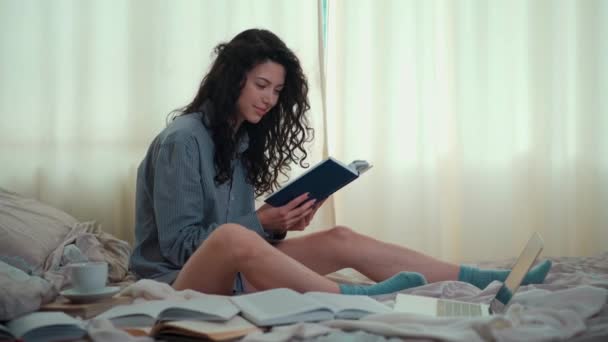 Bonita mujer morena en la cama de la mañana con libros y café — Vídeo de stock