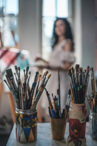 Mulher artista pintar com escovas e tintura de óleo — Fotografia de Stock