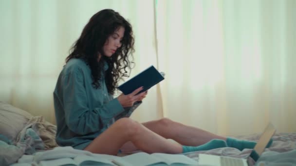 Hübsche brünette Frau im Morgenbett mit Büchern und Kaffee — Stockvideo