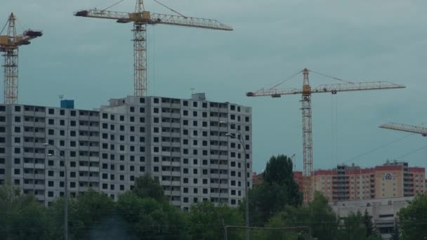 Краны и строительство современных жилых зданий — стоковое видео