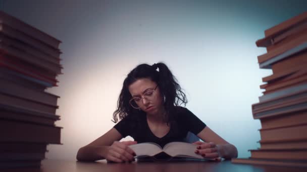 Ung flicka uttråkad av att läsa bok och göra läxor — Stockvideo