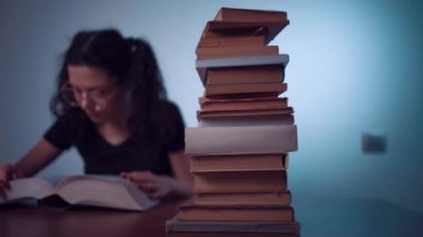 Genç kız evde çok ilginç bir kitap okuyor.