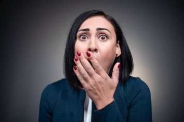 endişeli esmer kadın endişeleniyor ve parmaklarını ısırıyor.