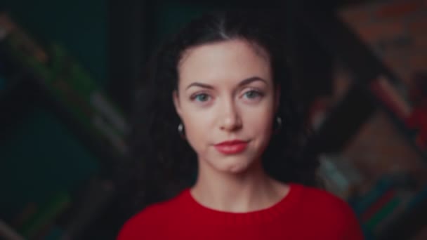 Jeune femme bouclée rester avec le livre et regarder la caméra — Video