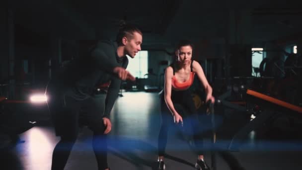 Cordes d'exercice féminines athlétiques dans la salle de gym moderne avec entraîneur personnel — Video
