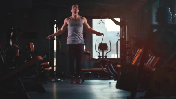 Красивый мужчина тренируется с скакалкой в тренажерном зале — стоковое видео