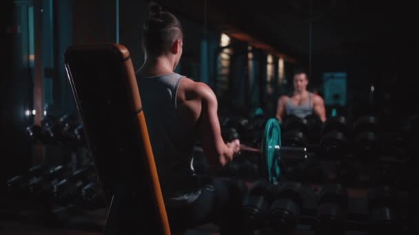 Atlético homem com perfeito torso exercitando com halteres no ginásio — Vídeo de Stock