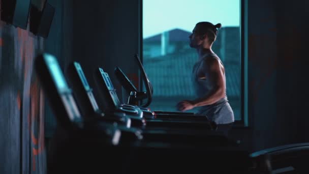 Stilig aktiv man som springer på löpband i modernt gym — Stockvideo