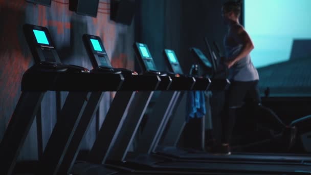 Красивий активний чоловік працює на біговій доріжці в сучасному тренажерному залі — стокове відео