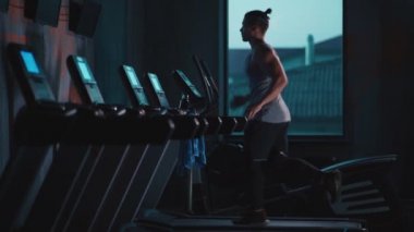 Modern spor salonunda koşu bandında koşan yakışıklı aktif bir adam.