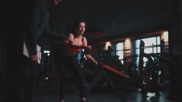 Cordes d'exercice féminines athlétiques dans la salle de gym moderne avec entraîneur personnel — Video