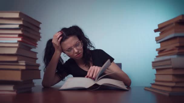 Молодая девушка устала от чтения книг дома — стоковое видео