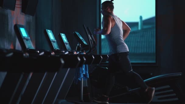 Guapo activo hombre corriendo en cinta de correr en moderno gimnasio — Vídeos de Stock