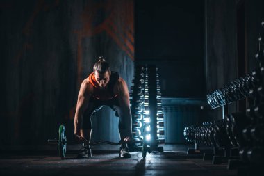 young athlete has physical workout with barbell in modern gym