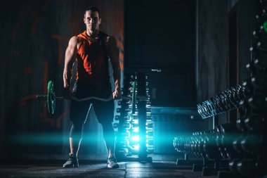 young athlete has physical workout with barbell in modern gym
