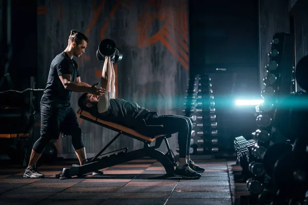 Young man has workout with personal trainer in modern gym — Stock Fotó