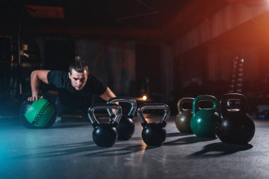 young man has crossfit workout with weight in gym