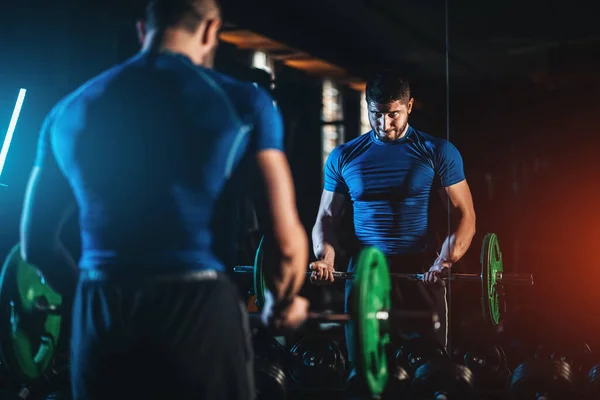 Young athlete has physical workout with barbell in modern gym — Stock Fotó