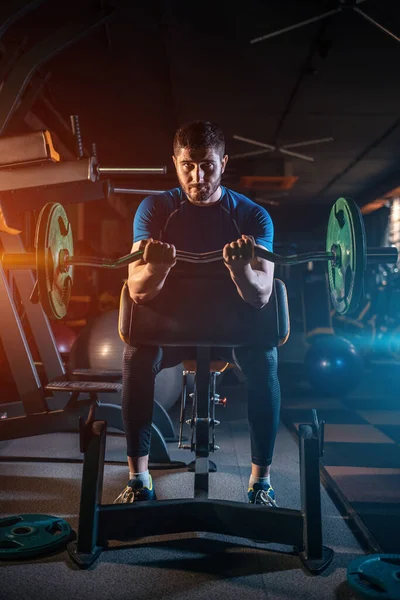 Atleta joven tiene entrenamiento físico con barra en el gimnasio moderno —  Fotos de Stock