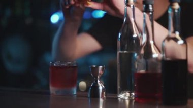 Barmen klasik negroni kokteylini rom ve buzla karıştırıyor.