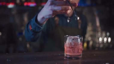 Barmen viski ve portakallı geleneksel kokteyl hazırlıyor.