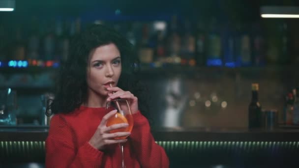 Junge lockige Frau trinkt köstlichen Cocktail in Nachtclub — Stockvideo